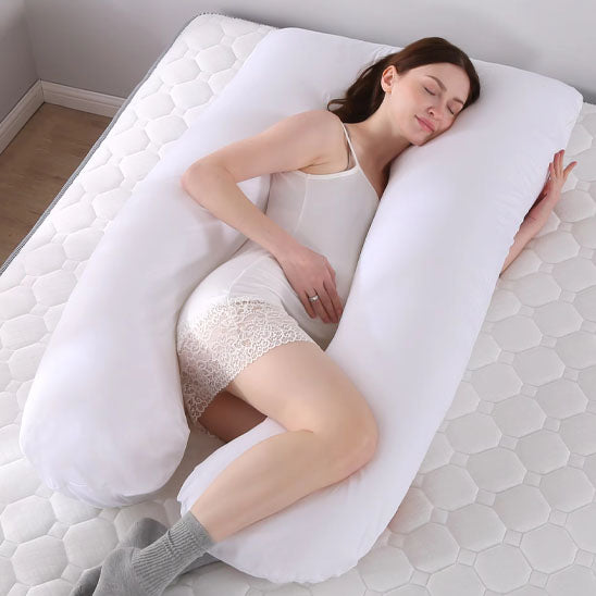une maman enceinte dors avec sa housse pour coussin de grossesse blanche remplie de bourre