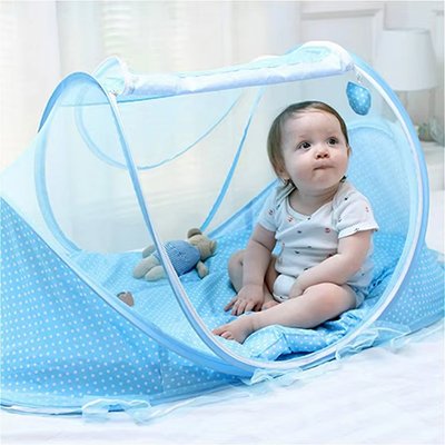 un bébé est assis dans un lit moustiquaire bleu très pratique