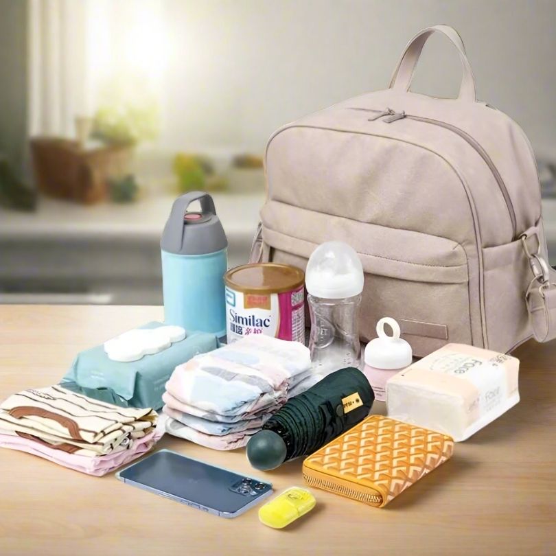 un sac à langer spacieux avec des accessoires à côté qui entrent dedans