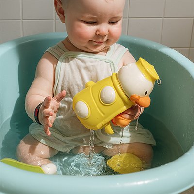Un bébé qui joue avec un jouet dans la baignoire.