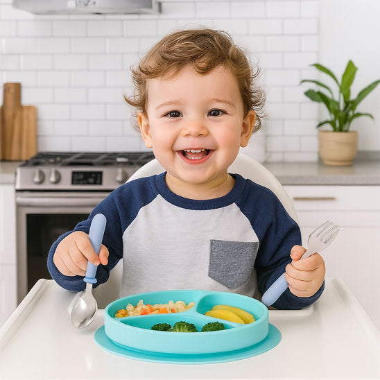 Un garçon qui mange avec les couverts bébé joyeux content