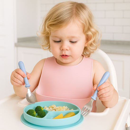 Une fille qui mange avec les couverts bébé bleu