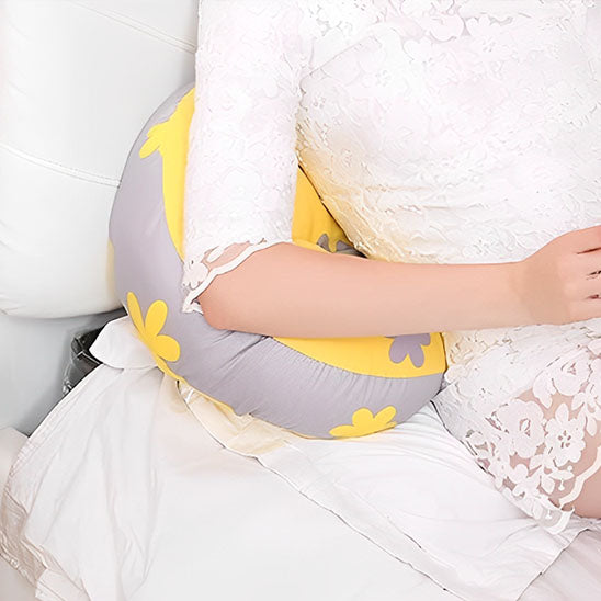 un coussin grossesse gris jaune sur lequel une maman enceinte est appuyée