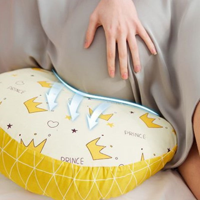 un coussin de grossesse jaune et blanc sur lequel une maman enceinte est appuyée