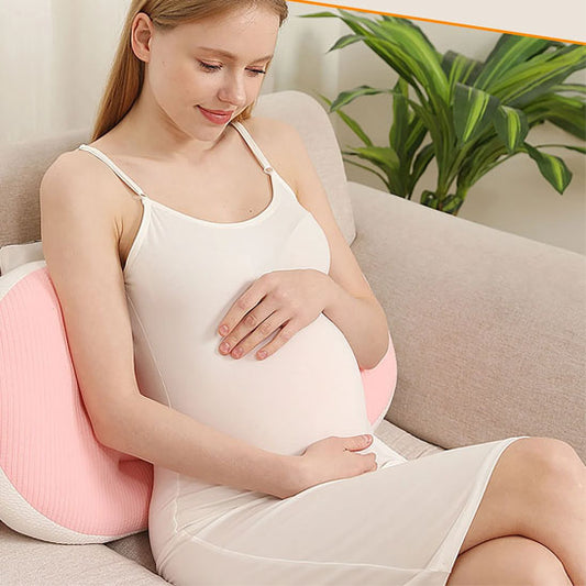 maman enceinte appuyée sur un coussin de grossesse rose