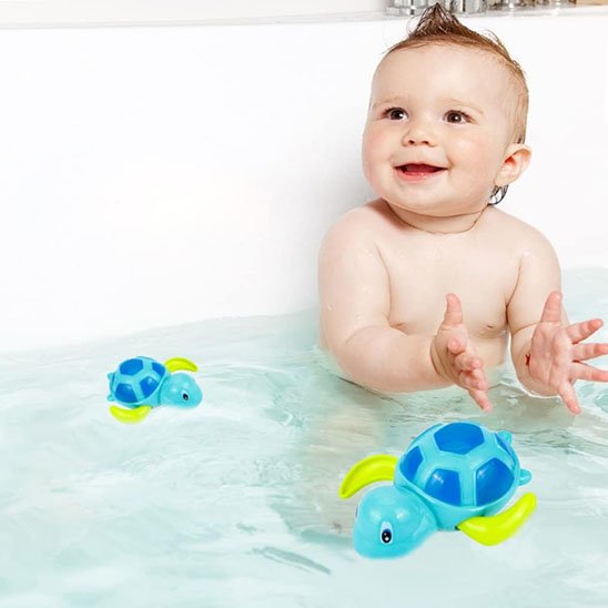 Un bébé qui est assis dans un bain, avec un jouet baignoire bébé