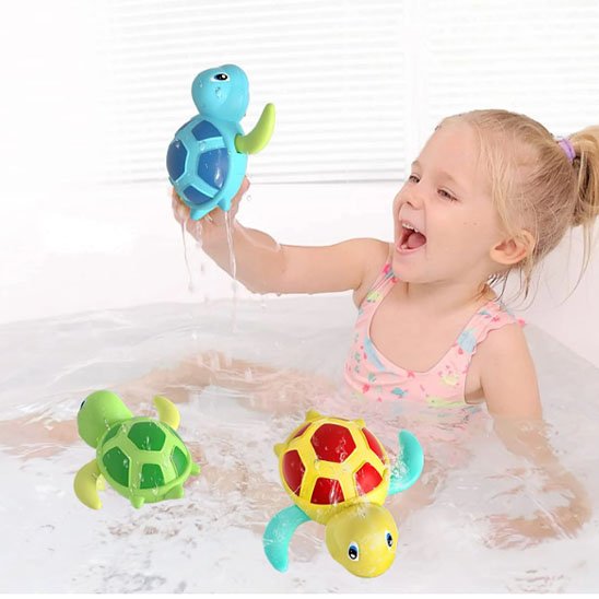 Une petite fille qui joue dans un bain avec jouet baignoire bébé